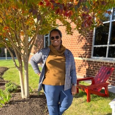 Photo of Mrs. Watford standing outside by a tree.